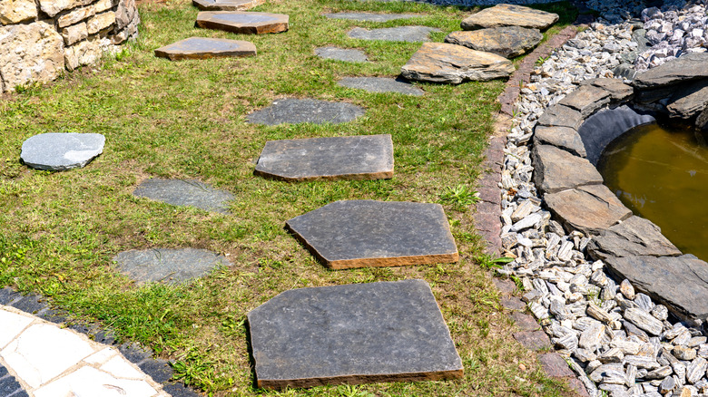 Rustic stepping stones arranged in a garden in the grass
