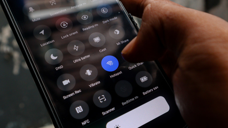Fingers turning on "Hotspot" on a mobile device