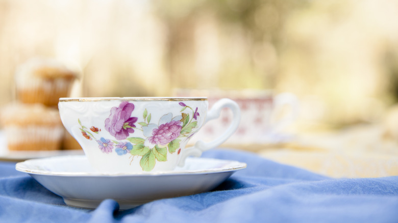 A floral teacup outdoors on a table