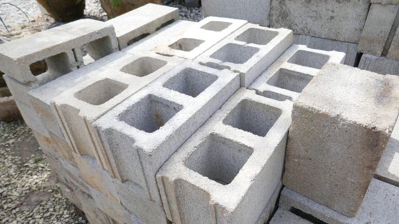 Light gray cinder blocks are stacked in a low pile.