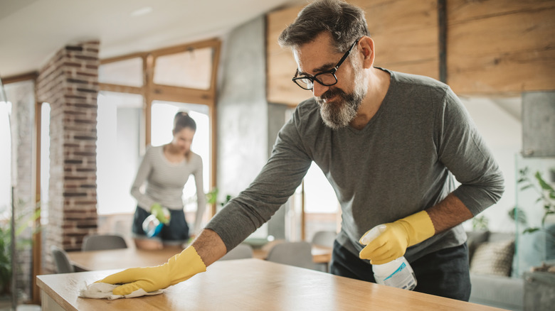 Man cleaning wooden table