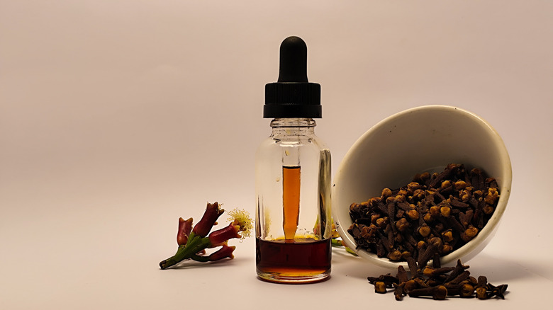 A small bowl of cloves and a small clear glass bottle