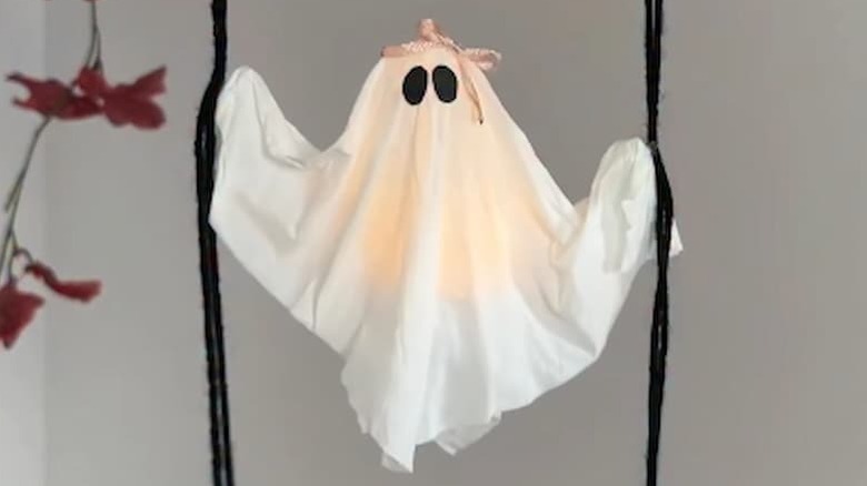 DIY ghost decor made from tissue hanging onto strings