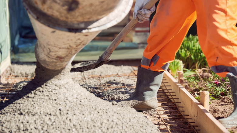 A person mixing cement in a yard