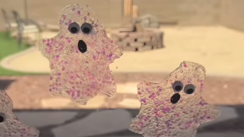 Ghost window clings on a window with glitter and googly eyes