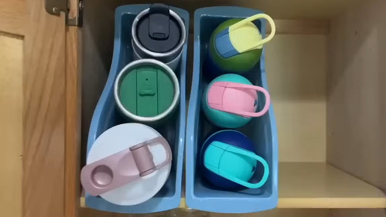 Woman placing Dollar Tree book bins in kitchen cabinet