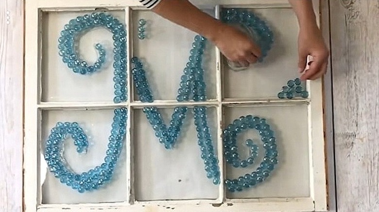 Woman creating DIY stained glass window out of Dollar Tree gems