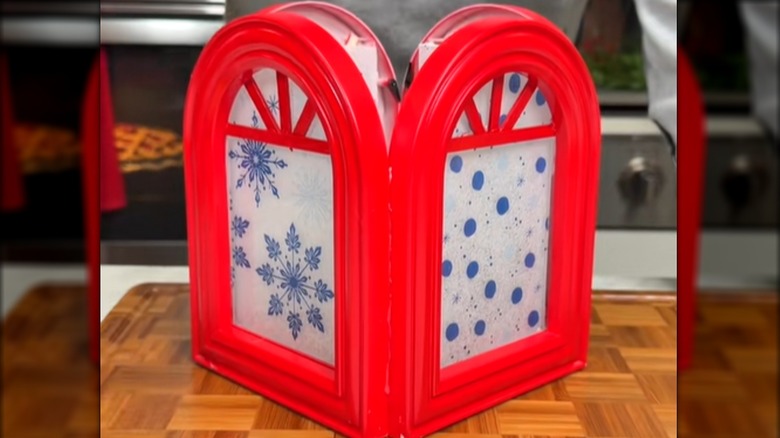 Four red-painted arched frames are glued together to make a lantern.