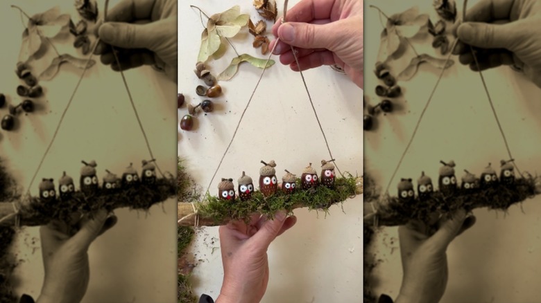 A hand holds up handmade owl-themed fall decor by the hanger.