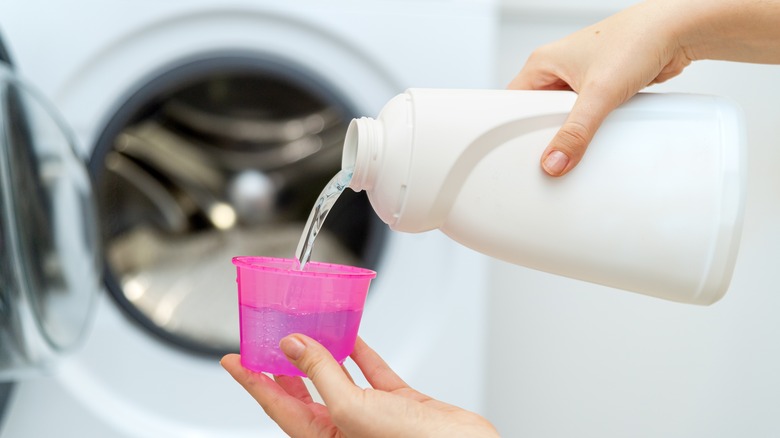 Someone pouring out detergent
