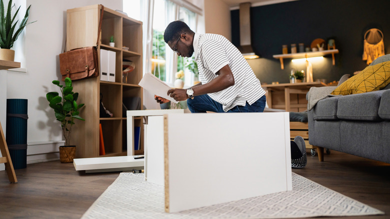 person building IKEA furniture in a living room