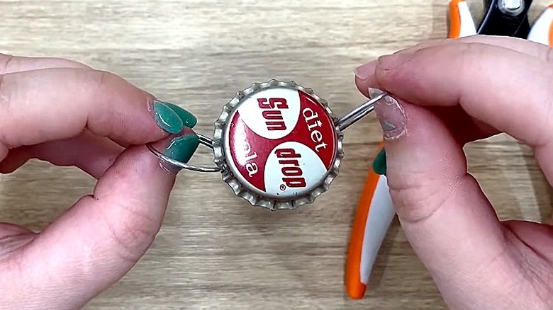 Demonstrator displaying threaded bottle cap using a keychain