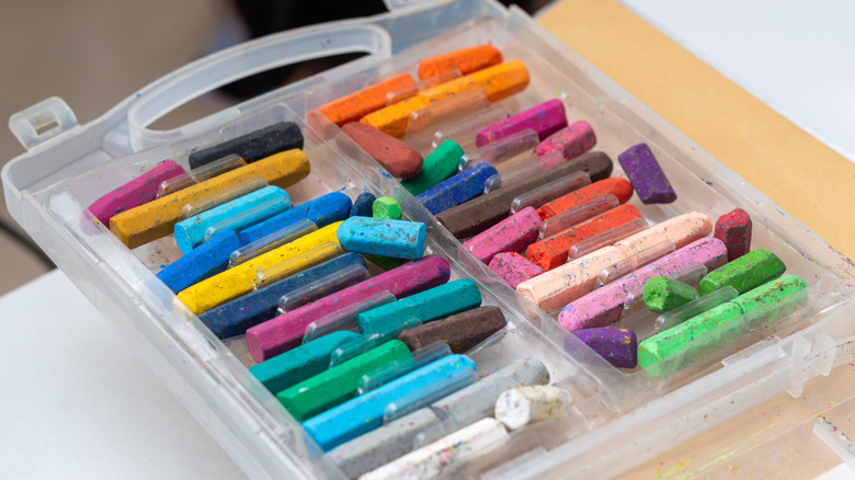 Plastic container full of assorted multi-colored crayons