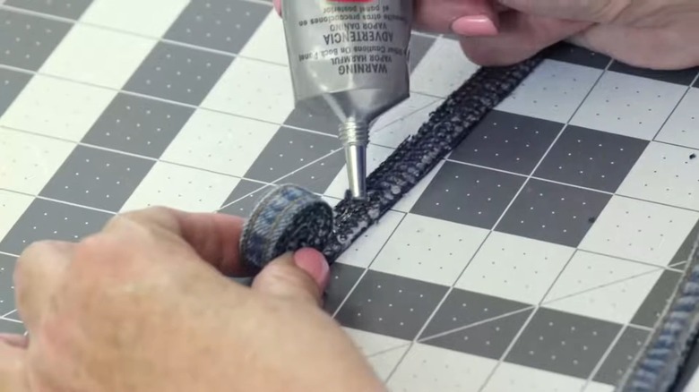 Female hands applying glue to rolled up jean strips