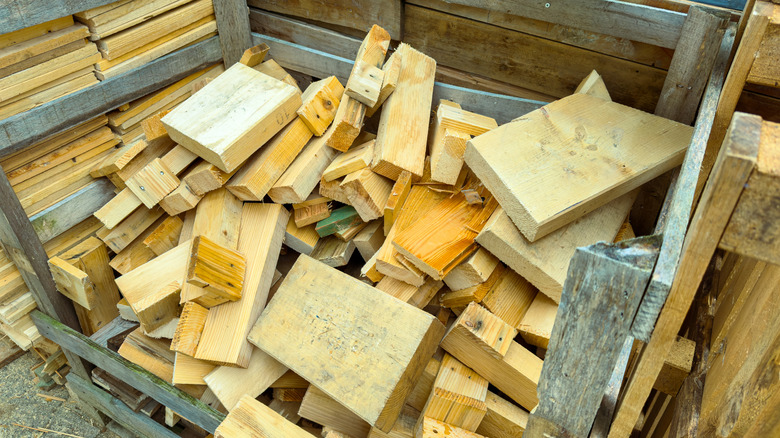 Pieces of light wood of various sizes are haphazardly tossed in a pile.