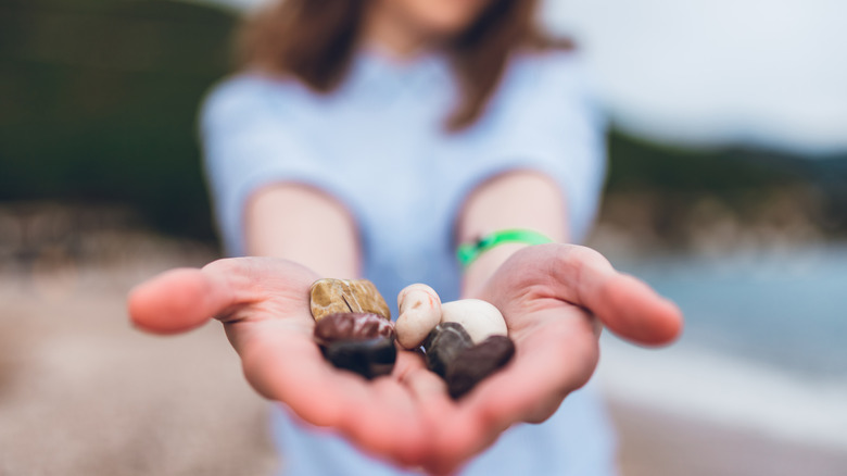 Woman holding a handful of stones.