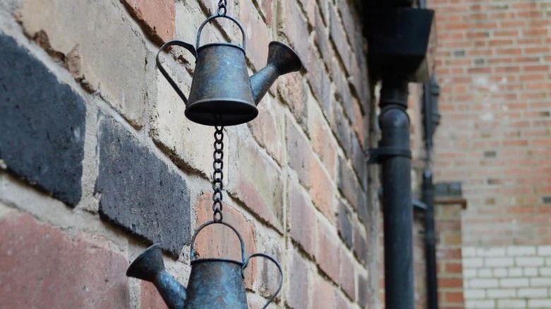 watering can rain chain hanging on brick wall