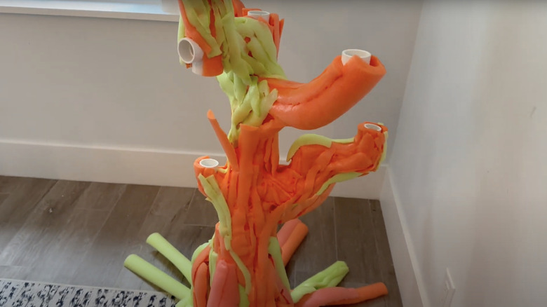 Structure of the pool noodle Halloween tree with the pool noodles fitted over PVC pipe branches