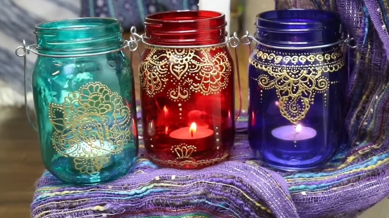 Painted glass jars with candles inside