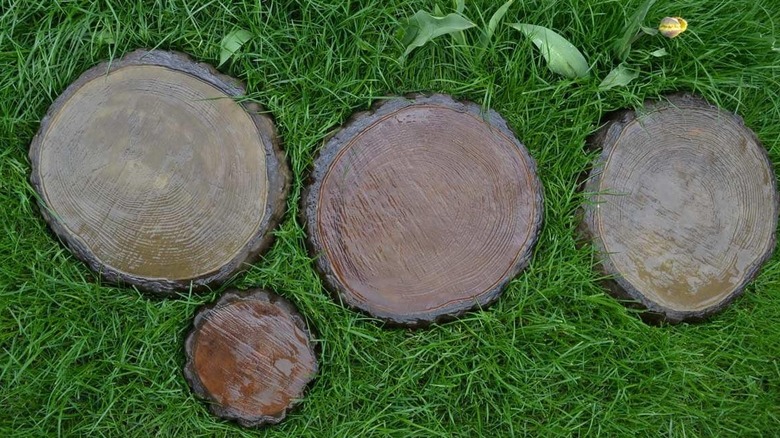 Painted concrete tree stump stepping stones in the grass