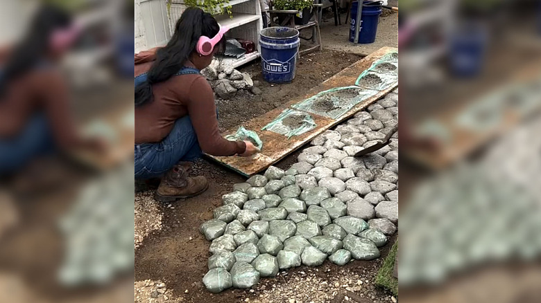 Person making budget-friendly DIY pavers