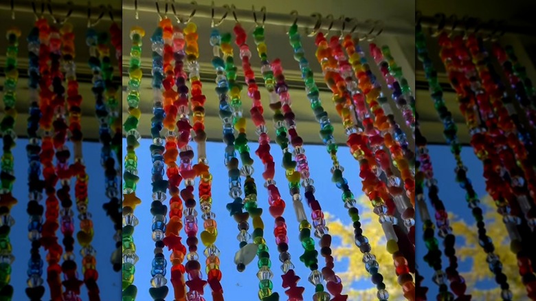 A DIY beaded curtain hung in a window with binder rings.