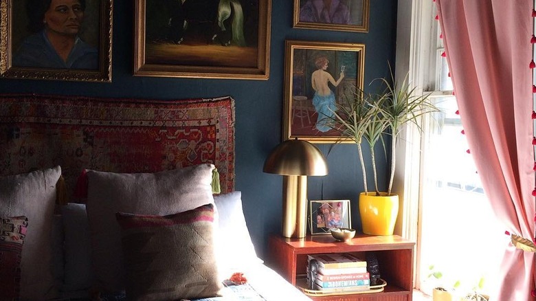 Thrifted art and rug behind bed in a room