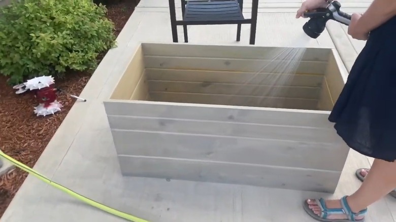 Woman filling DIY Japanese soaking tub with water.