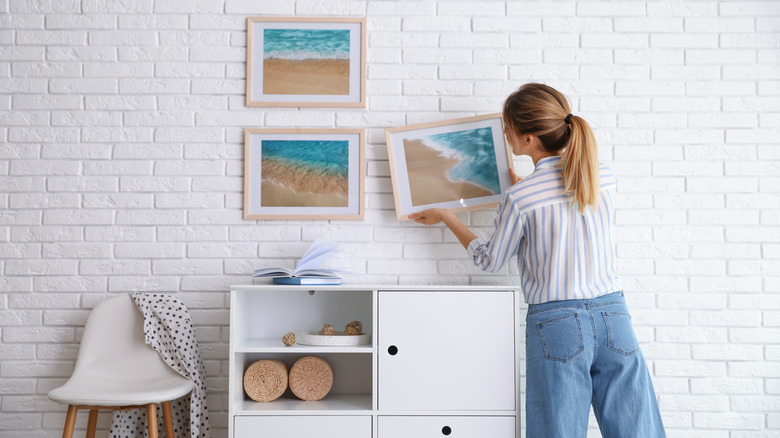 Woman putting up wall art