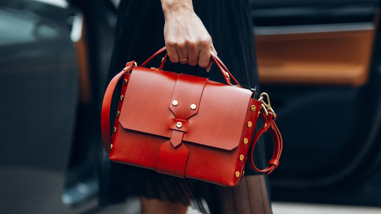woman holding red purse