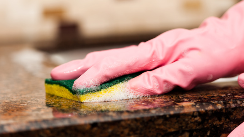 Person cleaning granite countertop