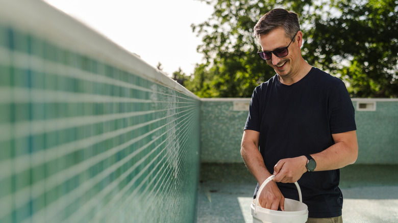 man holding bucket in pool