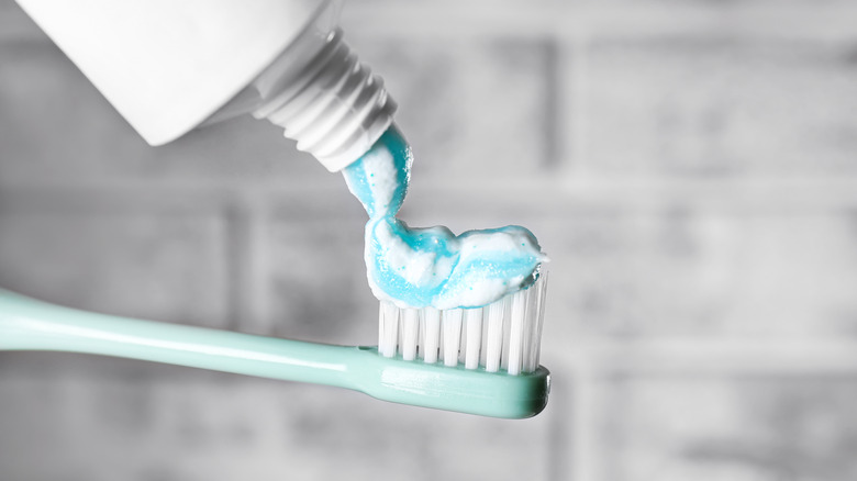 squeezing toothpaste on brush 
