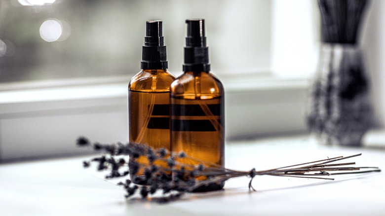 Two amber glass spray bottles sit on a counter.