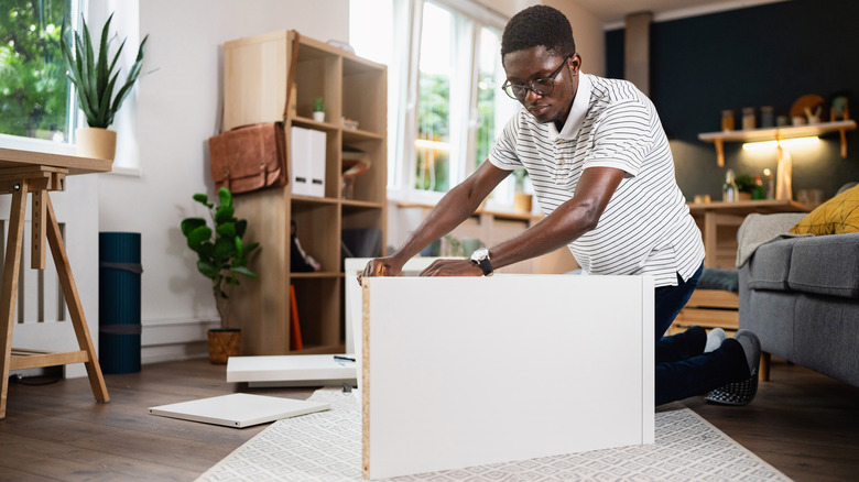 man assembling a bookshelf