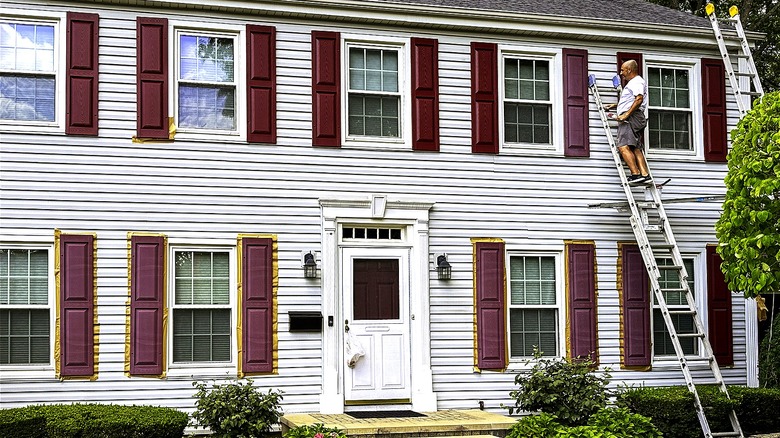 person painting aluminum siding