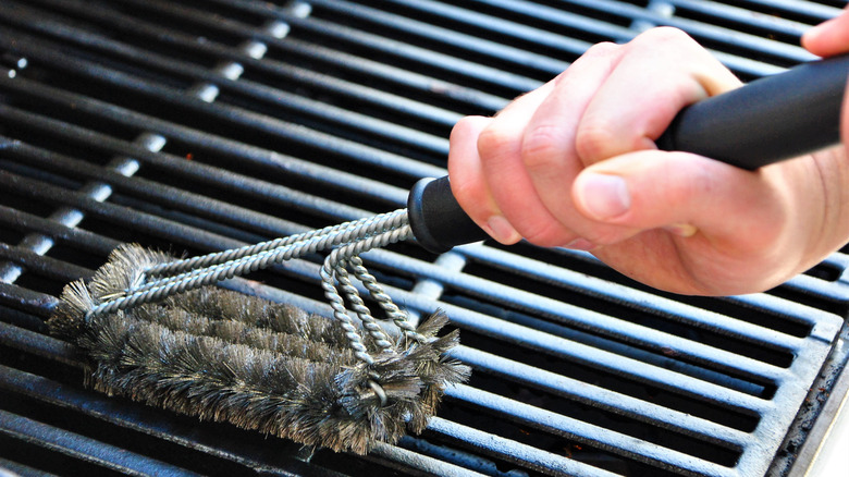 Person scrubbing grill grates