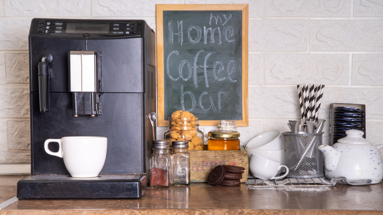 A small, somewhat disorganized coffee bar on a countertop