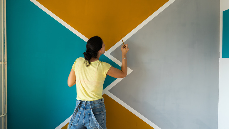 Woman painting interior wall