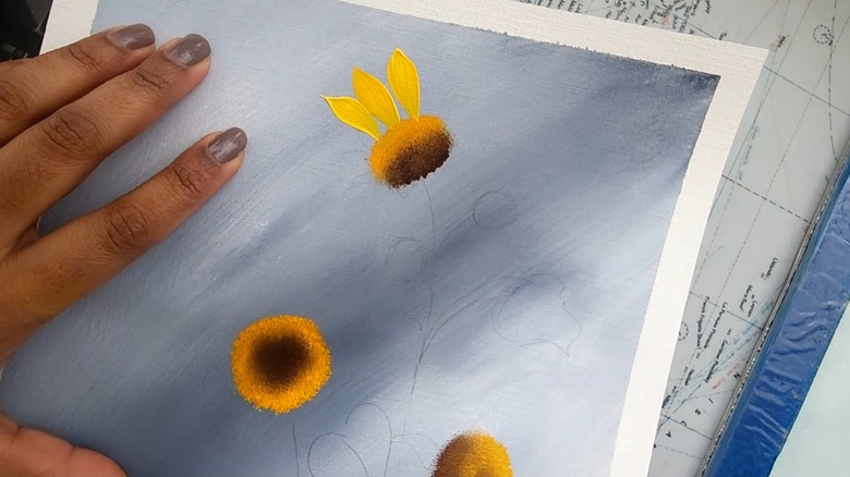 Woman painting sunflowers on canvas paper