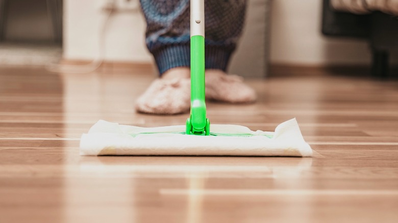 Person cleaning floor with a Swiffer