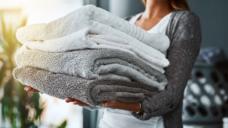 Woman holding a stack of four folded towels