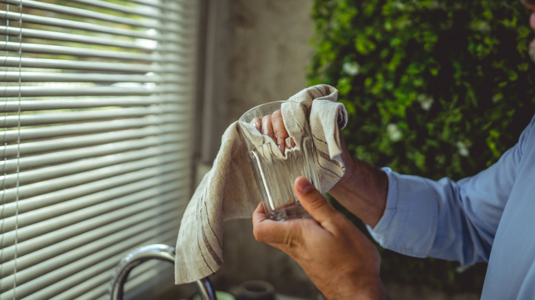 Man drying a glass with a towel