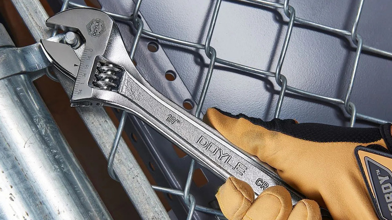 Person using DOYLE 10-Inch Adjustable Wrench to tighten fence bolt