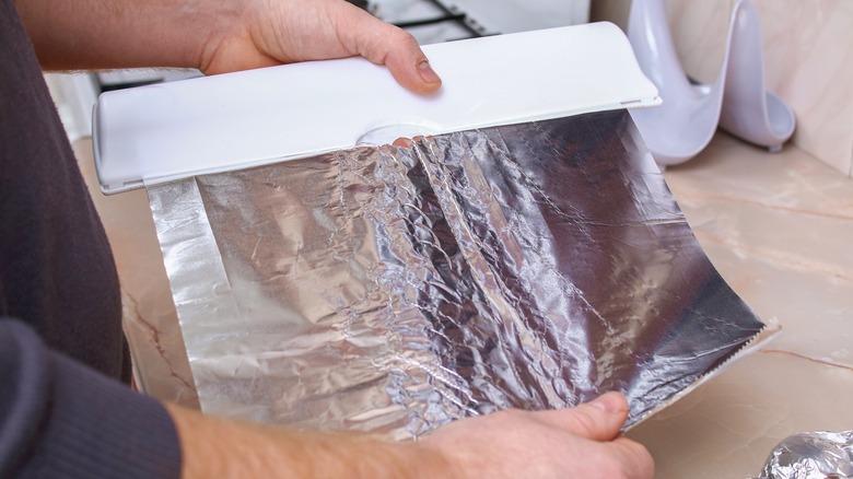 Hand tearing foil from container
