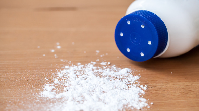 Talcum powder on wooden background.