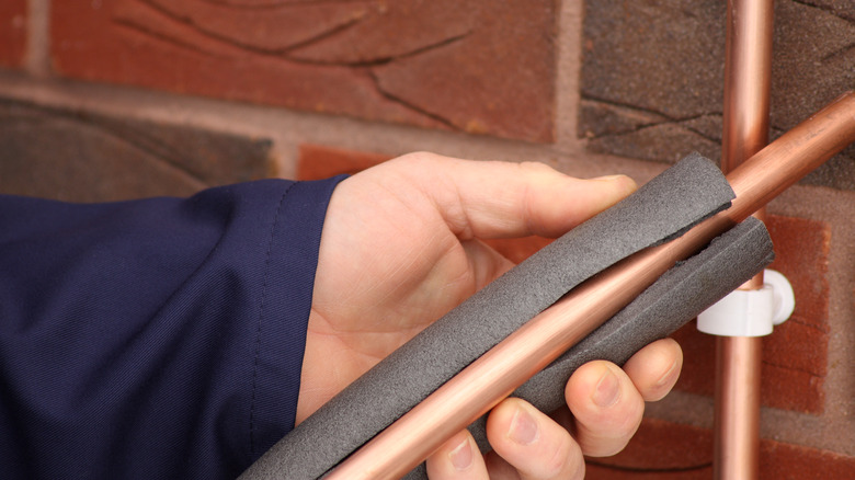 person insulating pipe