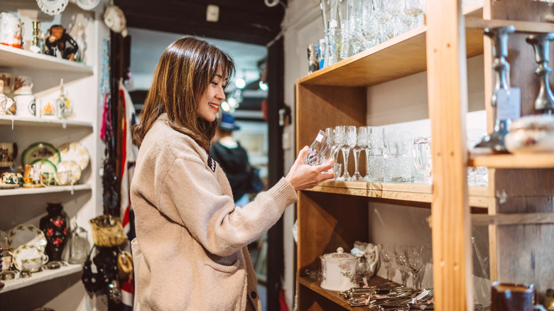 A person browsing glassware at an antique store