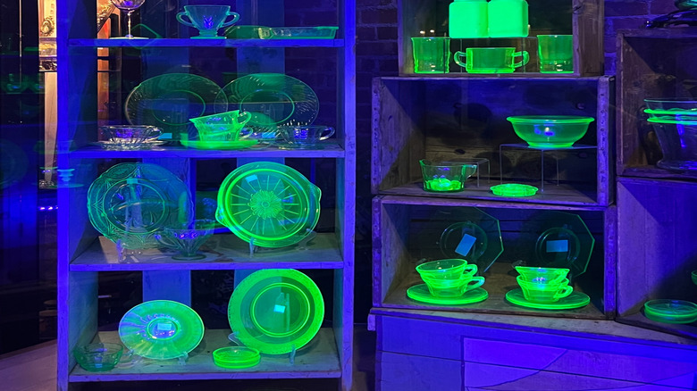 A display of Uranium glass glows under a black light