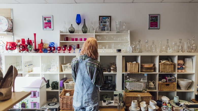 woman shops the kitchenware aisle at the thrift store